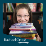 Smiling woman with glasses holding a stack of colorful children's books, with bookshelf in the background.